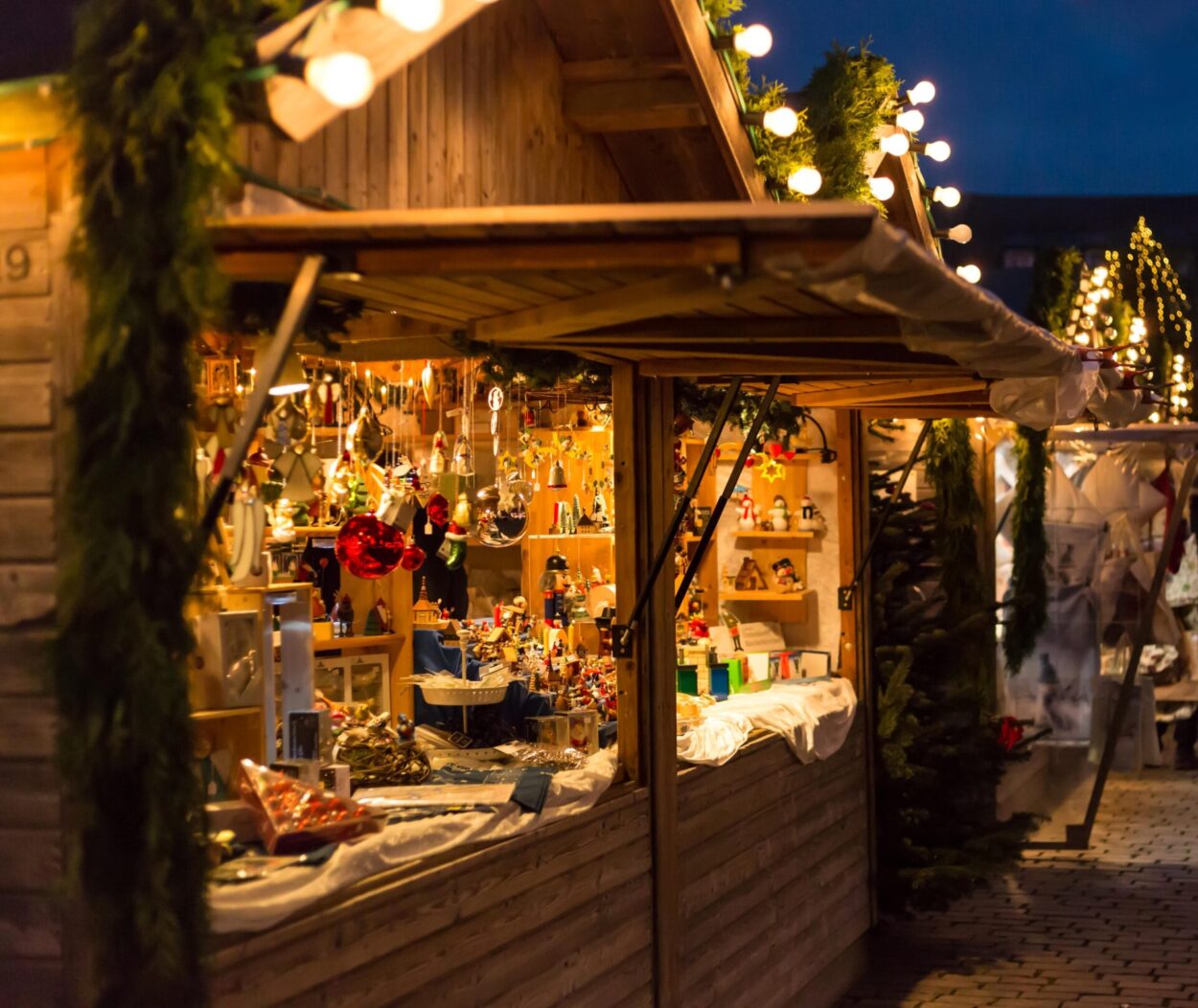 one of Christmas stalls bedecked with fairy lights and laden with variety of gifts