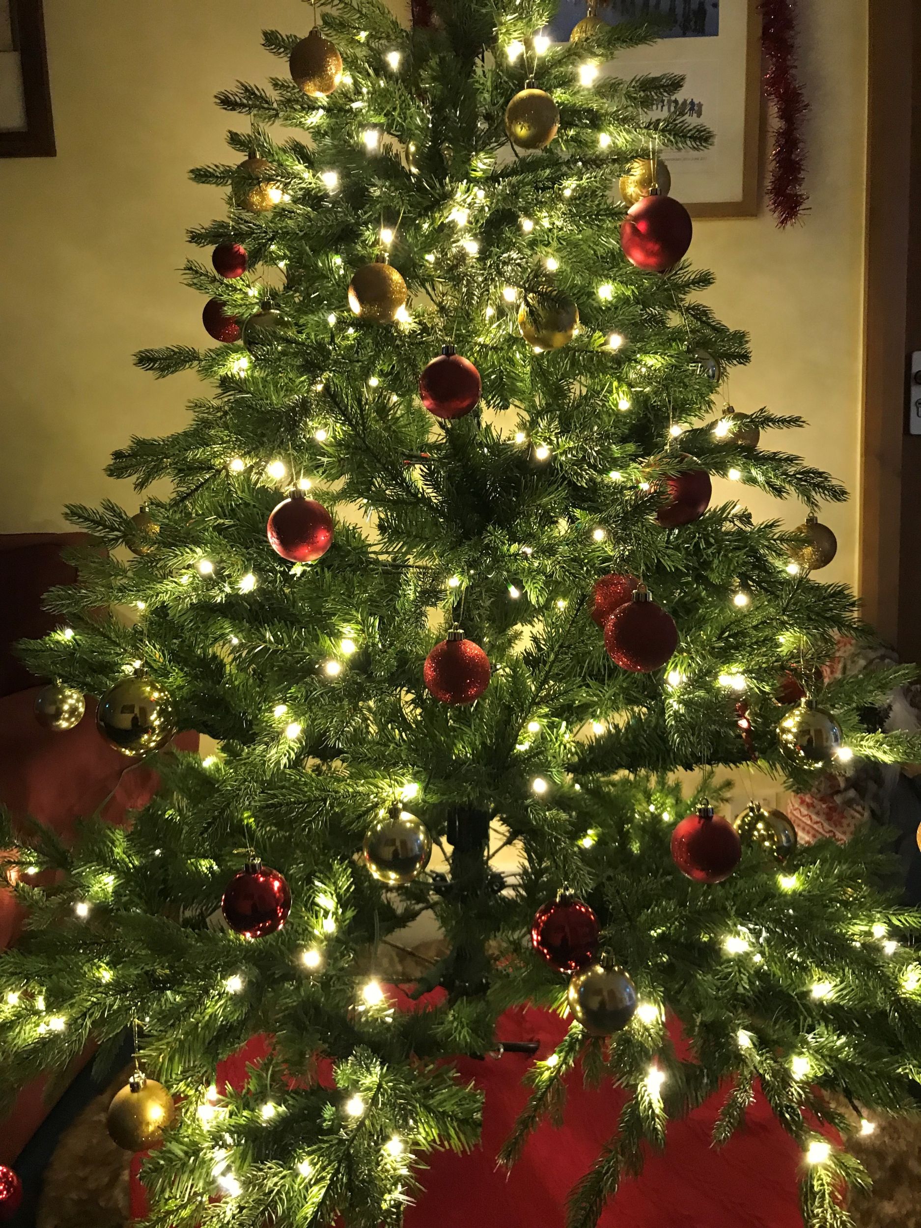A Christmas tree with baubles, all brightly lit up